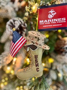 an ornament hanging from a christmas tree with the usmc boot and flag