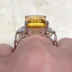 a fancy yellow diamond ring on someone's finger