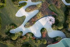 an aerial view of a golf course in the middle of trees and grass, with a swimming pool