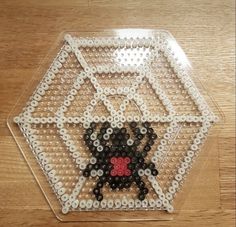 a plastic tray that has some beads in the shape of a dog on it, sitting on top of a wooden table