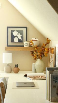 a white table topped with books and a vase filled with flowers