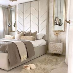 a bedroom with a bed, dresser and mirror on the wall in front of it