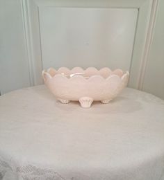 a pink bowl sitting on top of a white table