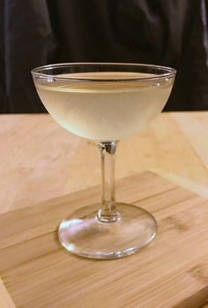 a glass filled with liquid sitting on top of a wooden table