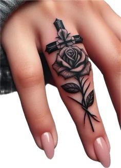 a woman's hand with a cross and rose tattoo on it