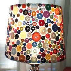 a lamp that has buttons on it in the shape of a handbag hanging from a hook