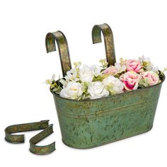 an old metal tub filled with flowers next to a pair of scissors on a white background