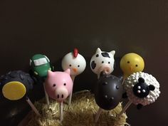 there are some cake pops that look like farm animals on top of hay and straw