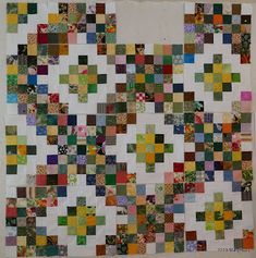 a large patchwork quilt with many different colored squares on it's back and sides