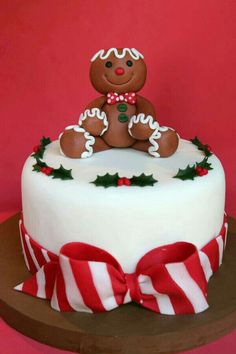 a christmas cake with a teddy bear on top and candy canes around the edges