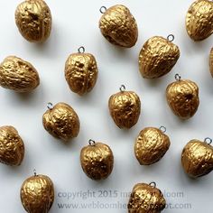 gold foiled acorns are arranged on a white surface