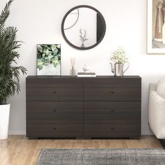 a living room with a couch, chair and large round mirror on the wall above it