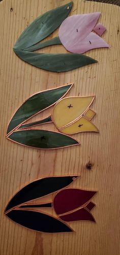 four different colored leaves on top of a wooden table