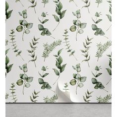 a white wall with green leaves on it