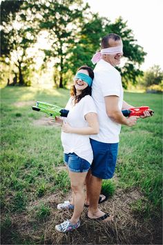 a man and woman are standing in the grass with their arms wrapped around each other