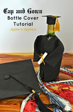 a graduation cap and gown sitting on top of a wooden table next to an apple