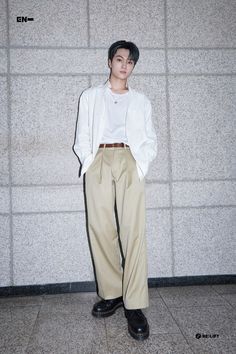 a young man standing in front of a wall