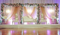 a decorated stage with chairs and flowers on it