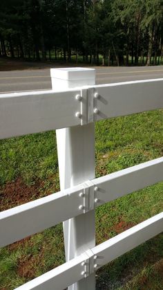 a white fence that is next to some grass