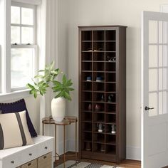 a living room filled with furniture next to a window and a plant in a vase