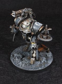 a warhammer with gears on it is standing on a black surface and looking at the camera