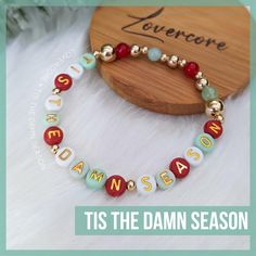 Friendship Bracelet text:  TIS THE DAMN SEASON.  Darn option available.     ✨ All gold spacers are 14k gold plated.  Acrylic beads are hand-buffed to eliminate manufacturer defects. 💖 All bracelets are made to order and will follow the color scheme selected. Bracelets measure approximately 7" unstretched and are made using high-grade elastic cord. Each bracelet is double-strung and secured with adhesive-reinforced knots to minimize the chance of breakage, however do take care to not overstretch. IF you require a size larger or smaller than the standard ~7", please leave a note with your order, I'm happy to accommodate.  Returns are not accepted, however if you have any issues with your order whatsoever, please don't hesitate to reach out so I can make it right. 💕 ABOUT LOVERCORE Handmade Elf Friendship Bracelet, Gold Beaded Bracelets For Christmas, Gold Beaded Christmas Bracelets, Handmade Gold Beaded Bracelets For Christmas, Handmade Gold Beaded Bracelets For Holidays, Christmas Bead Bracelet Ideas, Christmas Seed Bead Bracelets, Christmas Bead Bracelets, Christmas Beaded Bracelets