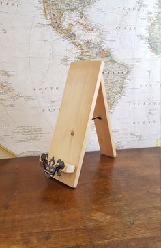 a small wooden easel sitting on top of a table next to a world map