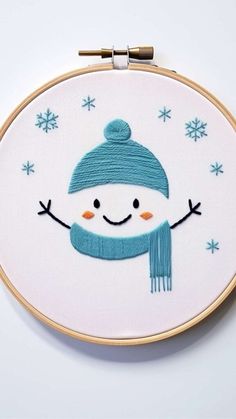 a snowman with a blue hat and scarf on it's face is shown in the hoop