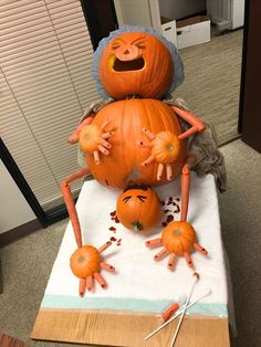 an orange pumpkin sitting on top of a table with two hands and legs attached to it