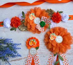 three orange and white flowers are on top of each other, with ribbons around them