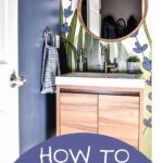 a bathroom with blue walls and white cabinets