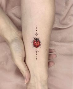 a ladybug tattoo on the left foot is shown in black ink with dots