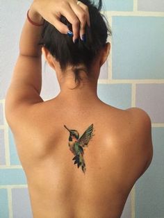 a woman with a hummingbird tattoo on her back