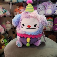 a stuffed animal sitting on top of a chair in a room filled with stuffed animals