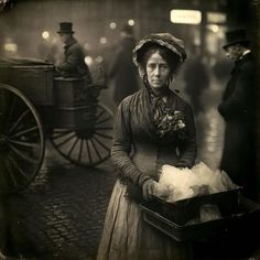 an old black and white photo of a woman holding a box