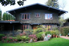 a large house with lots of plants in front of it