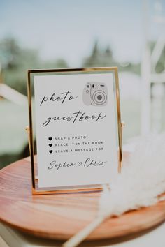 a wooden table topped with a sign and a white feather