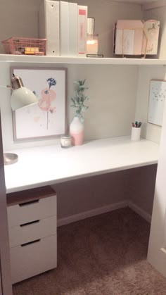 a white desk with two drawers and a vase on it in a room that has carpeted flooring