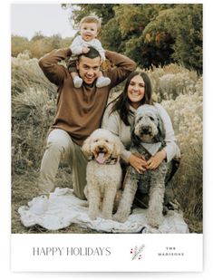 a man and woman with two dogs are posing for a holiday card that says happy holidays