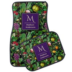 two mats with fruit and leaves on them, one has the letter m in purple