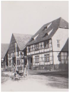 an old black and white photo of houses in the middle of town with water running through them