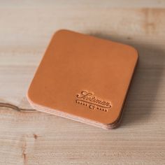 a brown leather coaster sitting on top of a wooden table