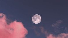 the full moon is seen through some pink clouds