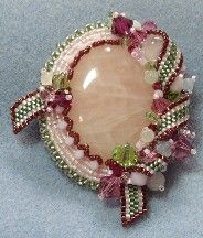 an image of a brooch with beads and flowers on it's back side