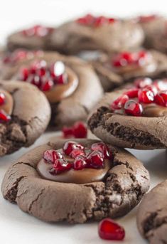 chocolate cookies with jelly on top are arranged in the shape of hearts and surrounded by red candies