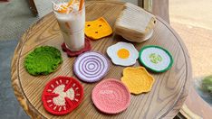 crocheted coasters are sitting on a table next to a glass of milk