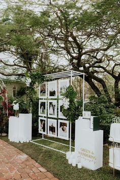 an outdoor ceremony setup with pictures and greenery