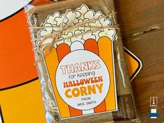 a bag of popcorn sitting on top of a wooden table next to an orange and white sign