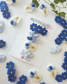 blue and white crocheted flowers are arranged on a table next to a card