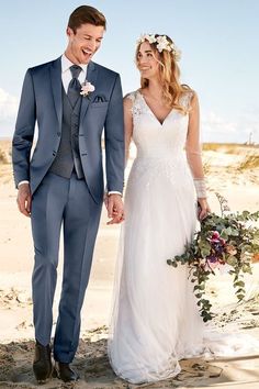 a bride and groom walking on the beach